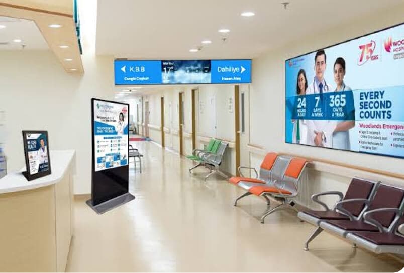 Patients and visitors viewing a digital screen in a hospital waiting area